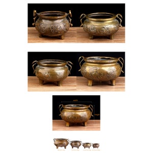 Puede incluir: Cuatro quemadores de incienso antiguos de latón con intrincados diseños florales. Los quemadores son de diferentes tamaños y tienen tres patas cada uno.