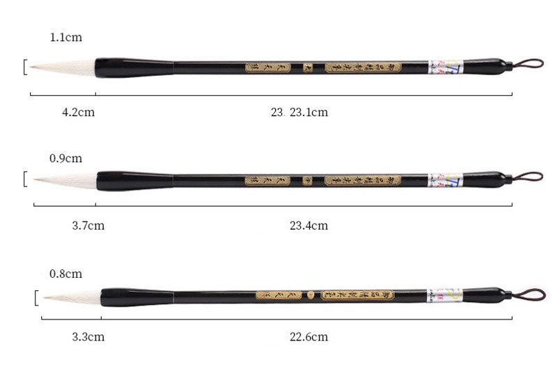May include: Three black and white calligraphy brushes with white bristles and black handles. The brushes are 23.1 cm, 23.4 cm, and 22.6 cm long. The brush bristles are 1.1 cm, 0.9 cm, and 0.8 cm wide. The handles are 4.2 cm, 3.7 cm, and 3.3 cm long.