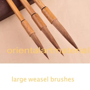 Puede incluir: Tres pinceles grandes de comadreja con mangos de madera y cerdas marrones. Los mangos son de color marrón claro y las cerdas son de un marrón más oscuro. El texto "oriental art material" es visible.