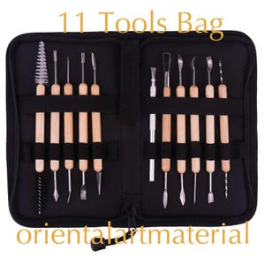 May include: A black zippered pouch containing 11 tools for sculpting and crafting. The tools are arranged in two rows and have wooden handles. The pouch has the text "11 Tools Bag" printed on the front and "orientalartmaterial" printed on the bottom.