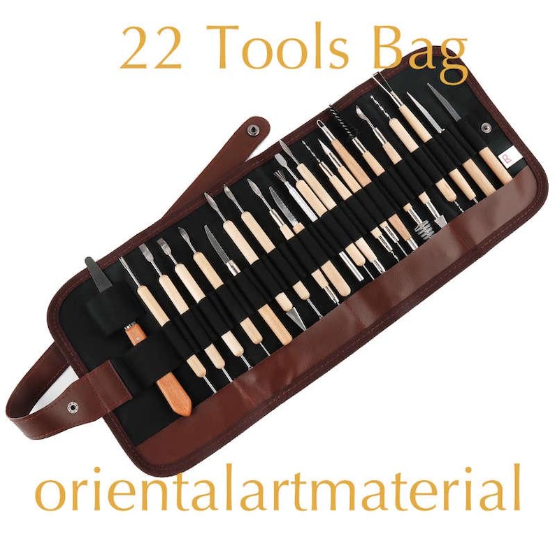 May include: A brown leather roll-up case containing 22 tools for sculpting and crafting. The case has a black fabric interior and a zip closure. The tools are made of metal and wood and are arranged in rows. The case is labelled "22 Tools Bag".