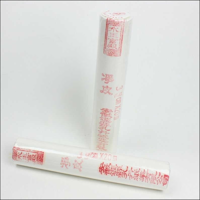 May include: Two rolls of white rice paper, each wrapped in plastic and labeled with red Chinese characters. The rolls are 3 cm wide and 20 meters long.