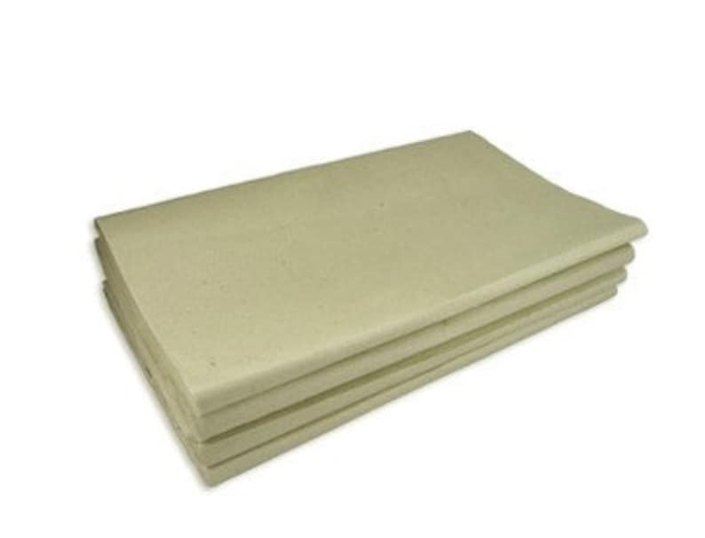 May include: A stack of four sheets of unbleached, off-white paper.