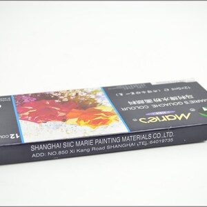 Puede incluir: Una caja azul de pintura gouache Marie's con una imagen floral en la parte delantera. La caja contiene 12 colores y est&aacute; fabricada por Shanghai Siic Marie Painting Materials Co., Ltd. El texto en la caja dice "Marie's Gouache Colour" y "12 Colours".