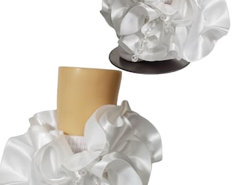 May include: Two white satin ruffled collar accessories with beaded accents. The collars are displayed on a mannequin, showcasing the layered, flowing fabric and delicate embellishments. The collars are designed to be worn around the neck.