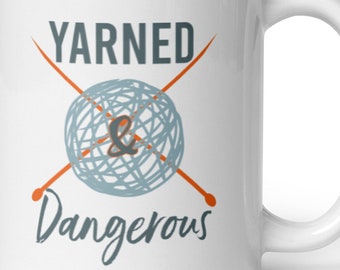 May include: White ceramic mug with a graphic of a ball of yarn and two knitting needles crossed over each other. The text "YARNED & Dangerous" is printed below the graphic.