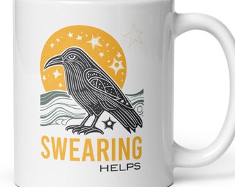 May include: White ceramic mug with a black and white illustration of a raven with a yellow sun and stars in the background. The text "SWEARING HELPS" is printed below the raven.