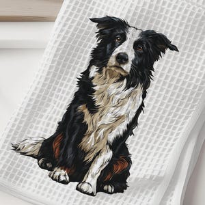 May include: White waffle-weave kitchen towel featuring a detailed illustration of a Border Collie dog. The dog is depicted in black, white, and brown, sitting upright. The towel is folded and placed on a white surface, suggesting a home decor item.