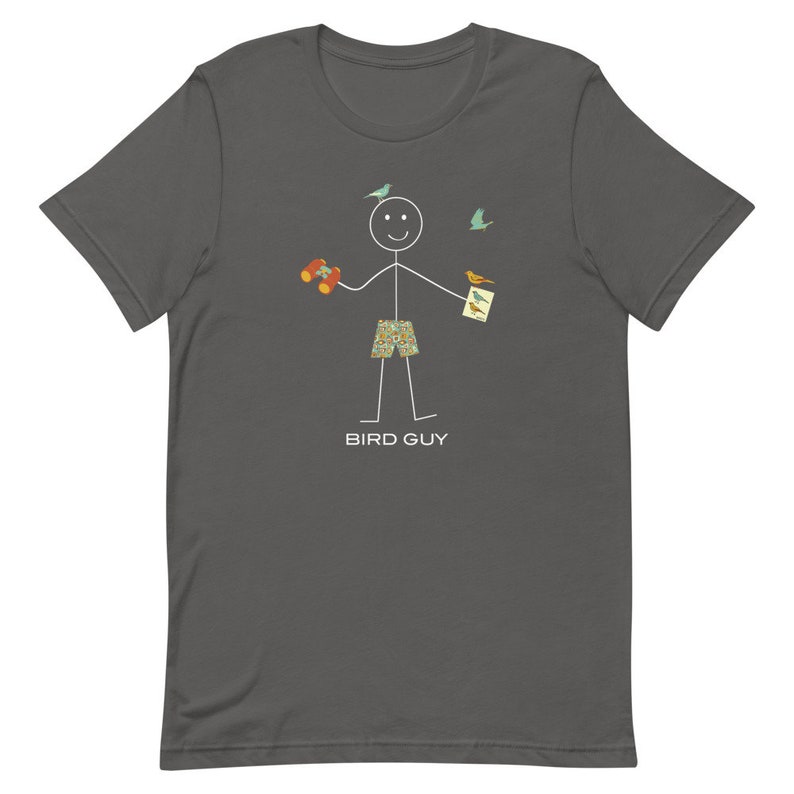 May include: Dark gray t-shirt featuring a stick figure with binoculars, bird watching guide, and patterned shorts. The stick figure is smiling with birds flying around. The text "BIRD GUY" is printed below the figure.