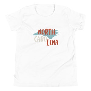 May include: White t-shirt with a blue outline of the state of North Carolina and the text "NORTH CAROLINA" in red.