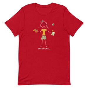 May include: Red t-shirt with a stick figure illustration of a person holding binoculars and a bird watching guide. The text "BIRD GIRL" is printed below the illustration.