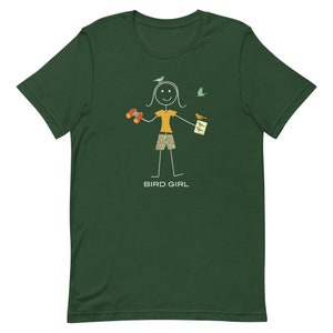 May include: A green t-shirt with a stick figure illustration of a person holding binoculars and a bird watching guide. The text "BIRD GIRL" is printed below the illustration.