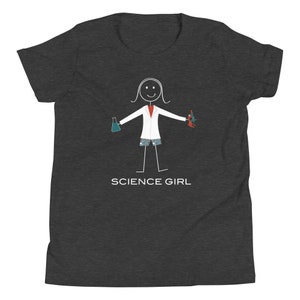 Puede incluir: Camiseta gris oscuro para j&oacute;venes con una ilustraci&oacute;n de figura de palo de una ni&ntilde;a que lleva una bata de laboratorio, sosteniendo un vaso de precipitados y un microscopio. El texto "SCIENCE GIRL" est&aacute; impreso debajo de la ilustraci&oacute;n.