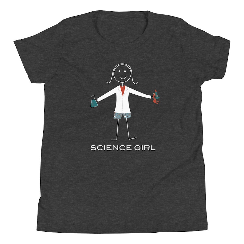 Puede incluir: Camiseta gris oscuro para j&oacute;venes con una ilustraci&oacute;n de figura de palo de una ni&ntilde;a que lleva una bata de laboratorio, sosteniendo un vaso de precipitados y un microscopio. El texto "SCIENCE GIRL" est&aacute; impreso debajo de la ilustraci&oacute;n.