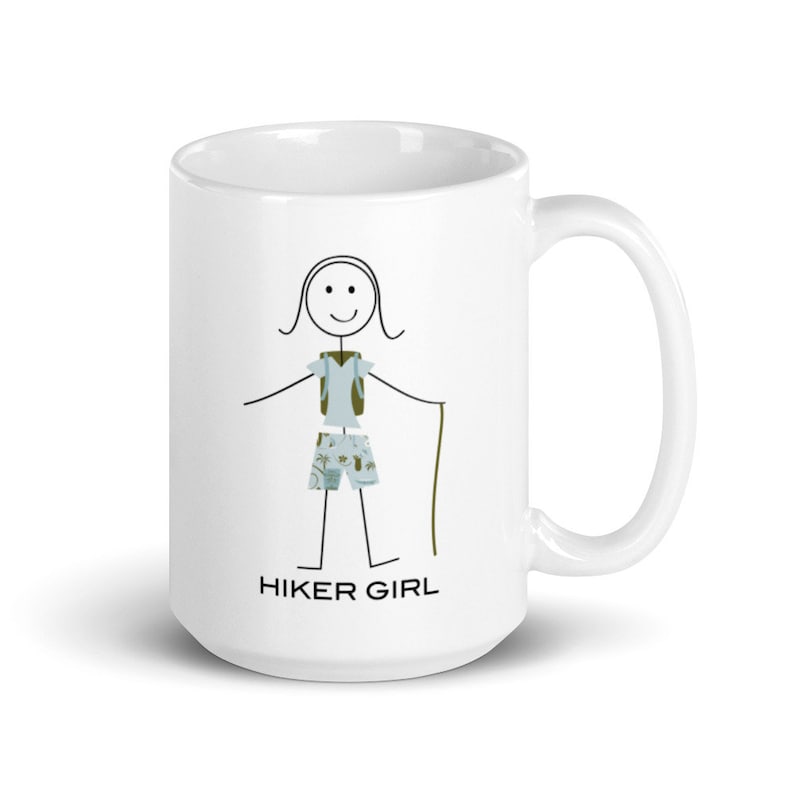 May include: White ceramic mug featuring a black stick figure illustration of a hiker wearing a blue shirt, green shorts, and a green backpack. The text "HIKER GIRL" is printed below the figure.