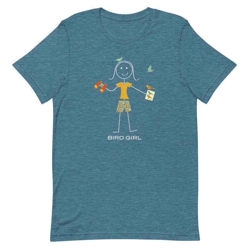 May include: A teal blue t-shirt with a stick figure illustration of a person holding binoculars and a bird identification book. The text "BIRD GIRL" is printed below the illustration.