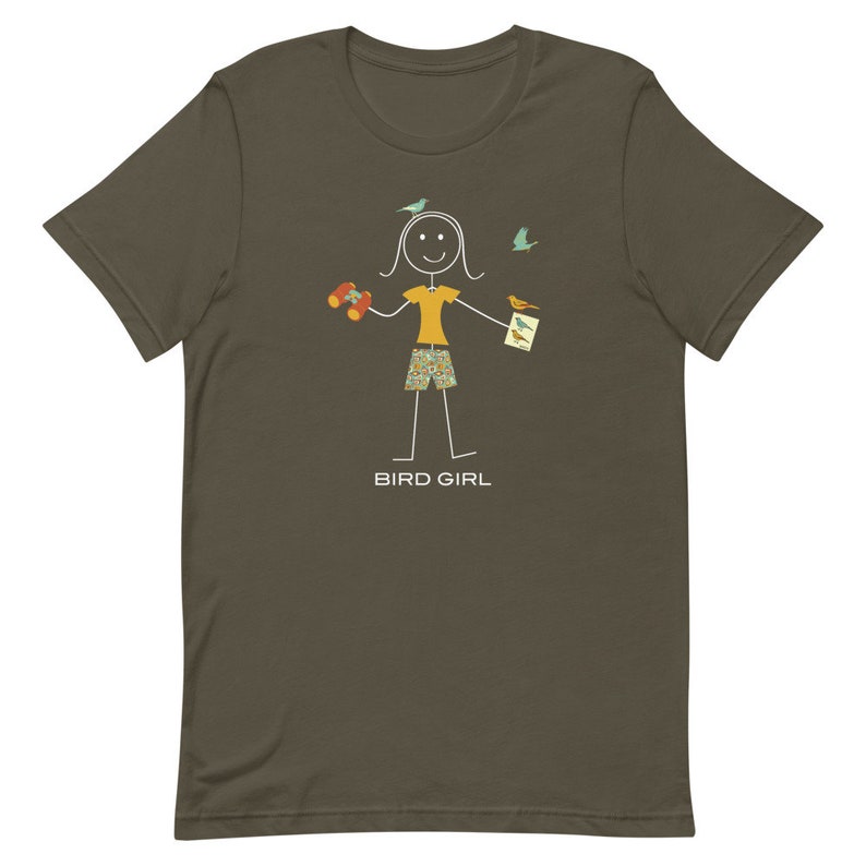 May include: A dark green t-shirt with a stick figure illustration of a person holding binoculars, a bird guide, and surrounded by birds. The text "BIRD GIRL" is printed below the illustration.