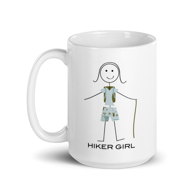 May include: White ceramic mug featuring a black stick figure illustration of a hiker with a backpack, shorts, and a walking stick. The text "HIKER GIRL" is printed below the illustration.