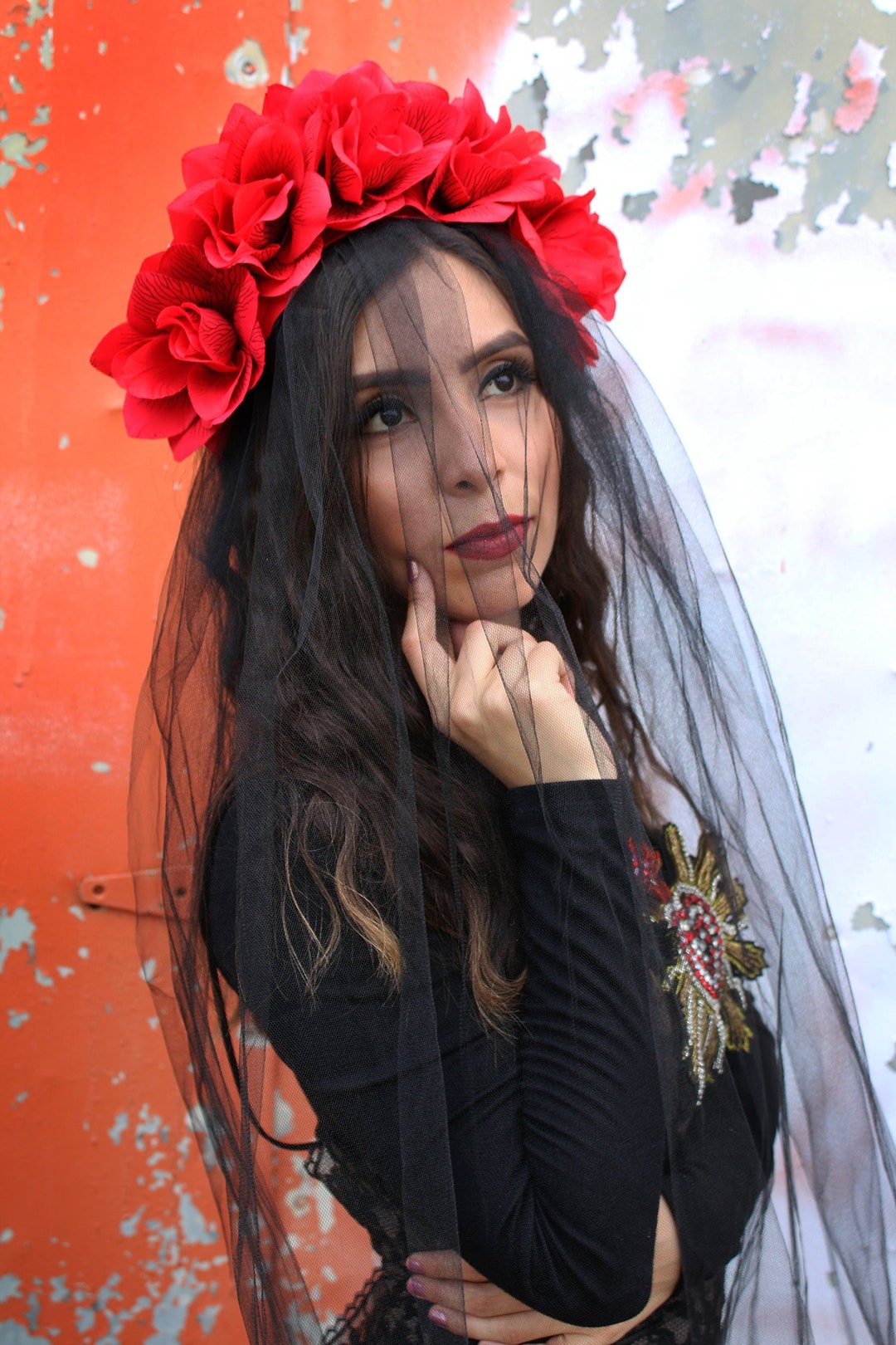 Mujer disfrazada de catrina con velo negro y arreglo floral en la
