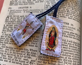 May include: Two religious fabric bookmarks with gold embroidery. The bookmark on the left features a depiction of Jesus Christ on the cross. The bookmark on the right features a depiction of the Virgin Mary. Both bookmarks have a white background with gold trim.