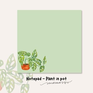 Op de afbeelding: Een lichtgroen notitieblok met een aquarel illustratie van een plant in pot in de rechter benedenhoek. De plant heeft groene bladeren en staat in een oranje pot. De tekst "Notepad - Plant in pot" staat onderaan.