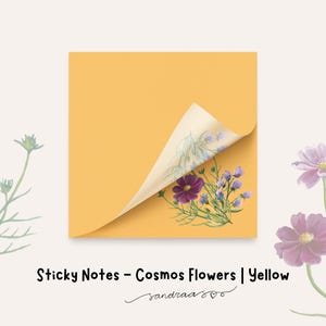 Puede incluir: Notas adhesivas amarillas con una esquina doblada, que revelan un diseño floral con flores de cosmos moradas y azules. El texto "Sticky Notes - Cosmos Flowers | Yellow" se muestra debajo.