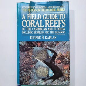May include: A Field Guide to Coral Reefs book. The cover is blue with white text and features two fish. The book is part of the Peterson Field Guide Series and includes information on the Caribbean, Florida, Bermuda, and the Bahamas.