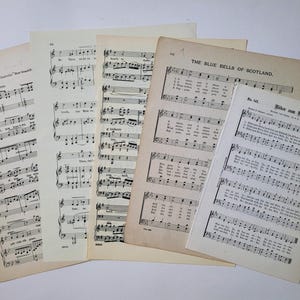 May include: A collection of vintage sheet music featuring songs like "The Blue Bells of Scotland" and "Wider den Kreuzzug". The music is printed on aged paper with a slightly yellowed hue.