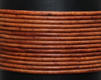 May include: Close-up of a spool of brown leather cord. The cord is wound tightly around the spool, creating a textured pattern.