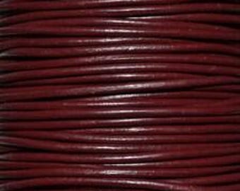 Puede incluir: Una longitud continua de cordón de cuero color burdeos oscuro enrollado firmemente en filas horizontales. El cordón tiene una superficie lisa y redondeada con un color rojo parduzco profundo y uniforme en toda su extensión.