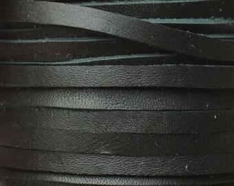 May include: Close-up of a spool of black leather strips. The strips are flat, thin, and stacked in neat, horizontal layers. The leather has a textured surface, and the edges of the strips are visible, creating a layered effect. The overall appearance is sleek and dark.