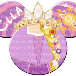 May include: A Disney-themed mouse ear headband featuring a princess design. The ears are purple and pink with the name "Ella" on one ear and "Disney Dream 2018" on the other. The center features a princess with a golden braid and a jeweled crown.