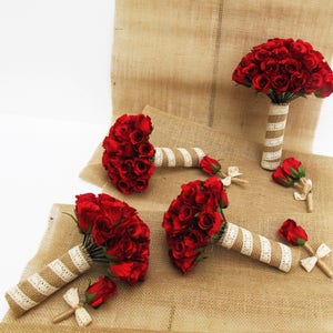 May include: Set of four red rose bouquets with burlap and lace wrapping. The bouquets are arranged on a burlap surface.