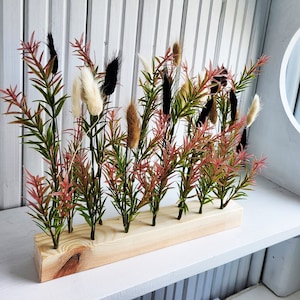 Decoración de colas de conejo y vegetación artificial sobre base de madera natural, plantas, flores, recepción, centro de mesa de bar, rústico en negro, verde, marrón y rojo.