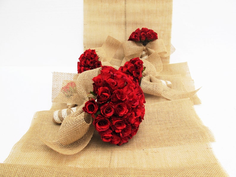 May include: Three bouquets of red roses wrapped in hessian fabric. The bouquets are arranged on a hessian background.