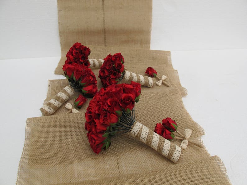 May include: Four red rose bouquets tied with white ribbon and hessian. The bouquets are arranged on a hessian surface.