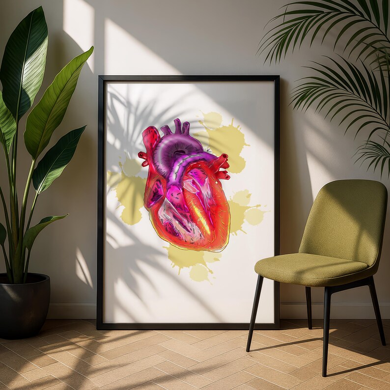 May include: A framed print featuring a vibrant, anatomical illustration of a human heart. The heart is rendered in shades of red, pink, and purple, set against a white background with yellow paint splatters. The artwork is displayed in a black frame.
