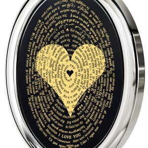 A black and silver oval pendant with a gold heart design. The heart is surrounded by words in different languages that translate to 'I love you.' The words are in a circular pattern around the heart.