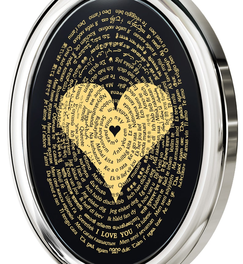 A black and silver oval pendant with a gold heart design. The heart is surrounded by words in different languages that translate to 'I love you.' The words are in a circular pattern around the heart.