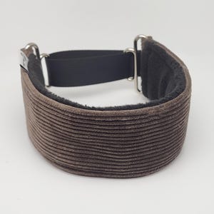 Op de afbeelding: Een bruine corduroy hondenriem met een zwarte fleece voering en zilveren metalen hardware.
