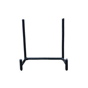 May include: A black metal display stand with a rectangular base and two vertical supports. The stand is designed to hold a plate or other decorative item. The stand is made of metal and has a simple, minimalist design.