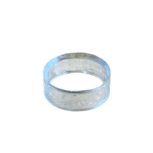 May include: A clear, transparent ring with a band of approximately 0.75 inches wide. The ring appears to be made of a solid, smooth material. The ring is circular and has a simple, minimalist design.