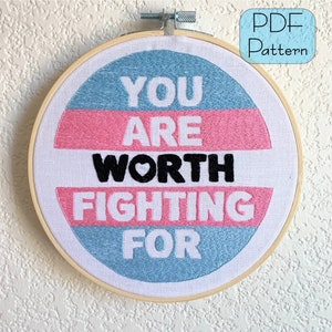 May include: Embroidered hoop art with a blue, pink, and white background. The text reads "You are worth fighting for" with a small heart symbol in the word "worth".