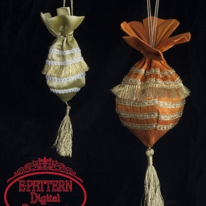May include: Two decorative fabric pouches with gold and white trim and tassels. The pouches are hanging from strings against a black background. The text "E-PATTERN Digital Download" is in a red oval frame.