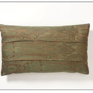 May include: A green and brown paisley patterned throw pillow with a decorative stitched design.