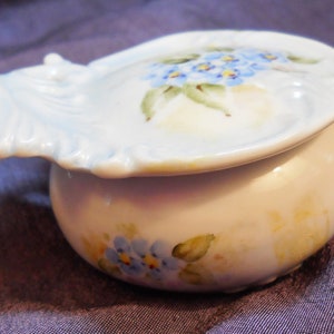 Vanity Bowl w/lid,hand-made & painted,blue flowers,1981,signed by the artist.  Porcelain,lid is 3” long,stands 1.5” tall.