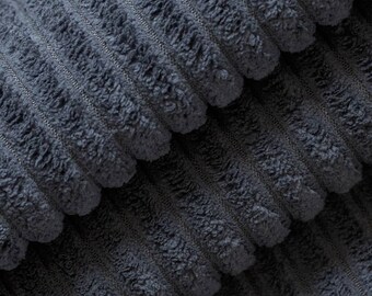 May include: Close-up of a dark blue corduroy fabric with a soft, textured surface. The fabric is folded in layers, showing the raised ridges of the corduroy.