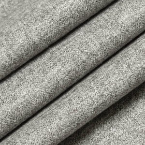 May include: Close-up of a gray, textured fabric. The fabric has a subtle woven pattern and a soft, slightly fuzzy surface.