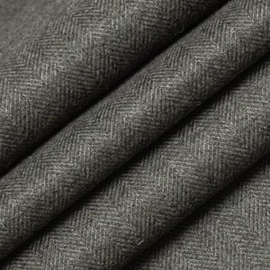 May include: Close-up of a dark gray herringbone fabric with a subtle texture. The fabric is folded in a way that shows the pattern and weave.