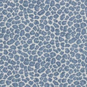 May include: Close-up of a fabric with a blue and white leopard print pattern. The design features irregular, rounded shapes in varying shades of blue against a white background. The fabric has a textured appearance.